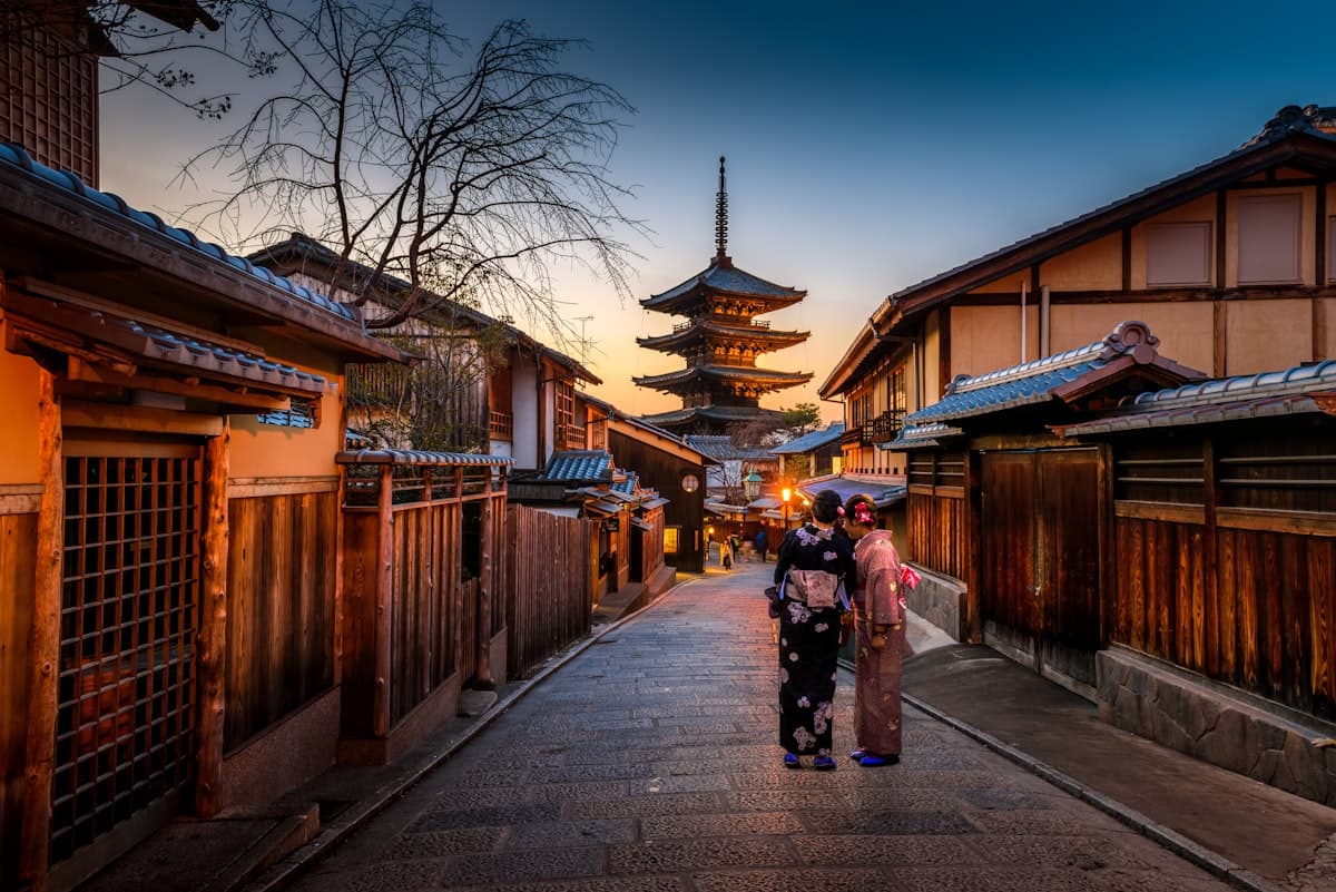 A lantern-lit Kyoto lane leading to a pagoda