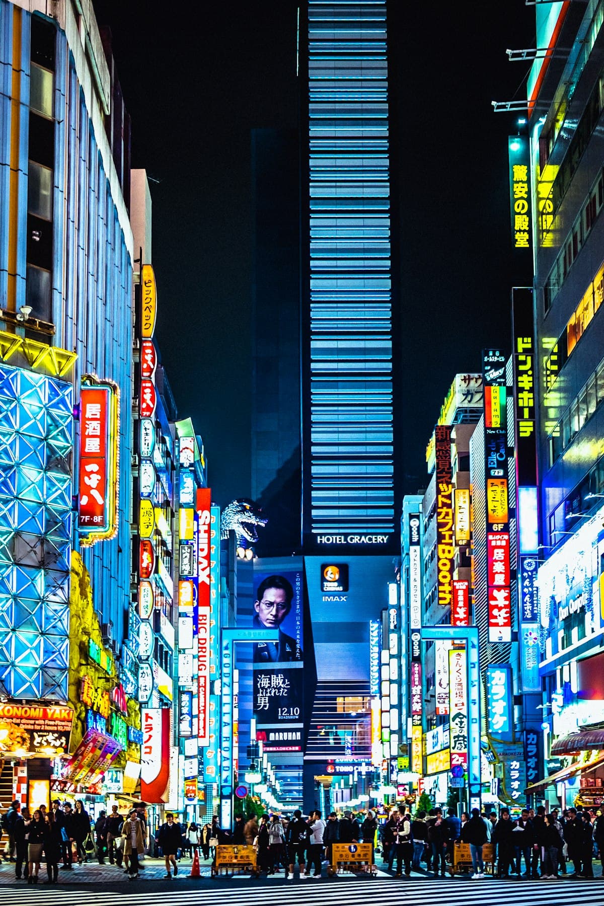 A Tokyo street at night under stacked neon signs